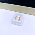 Elegante vergoldete Titanstahl-Ohrstecker mit Schraubverschluss und drei weißen Zirkonia. - Goldener Drei-Zirkonia-Reihenstil