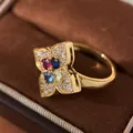 Elegant four-petal clover ring in gold finish pavé set with multi-colored gemstones. - Golden Colored Diamond Style