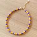 Detaillierte Makroansicht einer Vintage-Perlenkette mit lila und gelben runden Perlen - Französische Vintage-Halskette mit violett-gelben Perlen