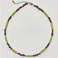 Detailansicht einer handgefertigten Perlenkette mit roten Edelsteinen und grünen Perlen - Französische Boho-Halskette mit grünen Perlen und lila Steinen