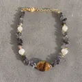 Vista dettagliata del bracciale con occhio di tigre e perle su tessuto grigio - Stile Pietra Perla Occhio di Tigre Ovale (B) / 17+3cm