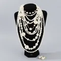 Elegante conjunto de collar y pendientes de perlas blancas multicapa en busto de joyería. - Set de collar y pendientes