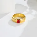 Detail of an elegant gold titanium steel ring featuring a vibrant red zircon solitaire - US 7 / Red Zirconia Gold Ring