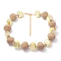 Vue détaillée d'un collier en perles de résine géométriques avec feuille d'or et cubes bruns. - Couleur Thé au Lait