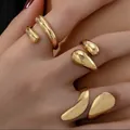 Gothic style chunky gold open rings with organic teardrop design on model's hand - Liquid Metal Teardrop Geometric Open Ring Set (6182501HB) / Set of 3 / Gold