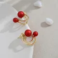 Elegantes pendientes de aro doble minimalistas con perlas rojas mate bañados en oro - Perla Roja (Ovalada Retro)