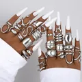 Juego de anillos plateados de estilo lava en manos con uñas blancas y piel oscura. - Juego de Líneas de Lava (6538801HB) / Juego de 29 piezas / Plateado