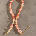 Gros plan d'un collier de plage avec des perles de pierre orange semi-transparentes - 38+5cm / Rouge Orangé