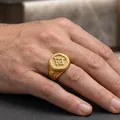 Primer plano de un anillo de sello masónico dorado con el símbolo de la escuadra. - US 7 / Dorado