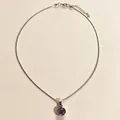 Vue détaillée d'un élégant pendentif en pierre violette sur une chaîne argentée fine - Violet