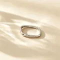 Close-up detail view of a minimalist silver titanium steel square ring with a small stone - US 4 / Silver