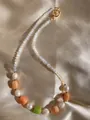 Gedetailleerde opname van handgemaakte kralenketting met parels op satijnen achtergrond - Matte Glazen en Parelketting 18 / 43cm