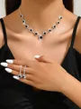 Detailed close-up of a sparkling crystal necklace and matching earrings worn by a model - 1229 Black