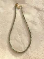 Detailed macro view of a slender natural stone beaded necklace on textured linen fabric - One Size / Green Brown Faceted Style (Style 26)