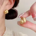 Close-up of gold brushed round stud earrings showing elegant matte metal texture - Gold 3D Brushed (ED2630-2)