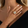 Anello vistoso color oro con cabochon rotondo bianco indossato da modella - Anello pietra preziosa crema traforato dorato (01085) / Oro chiaro + Bianco crema