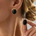 Orecchini vintage con pietra nera ovale e bordo dorato testurizzato indossati da una modella - Orecchini a Lobo con Pietra Nera Ovale (04062) / Oro + Nero