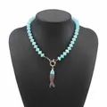 Dettaglio di una collana di perline azzurre con ciondolo a pesce su un manichino - Collana di Perline Blu Chiaro Pesce (N13494)
