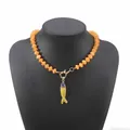 Primo piano di collana bohémien con perline arancioni e ciondolo a forma di pesce - Collana di Perline Arancio-Gialla Pesce (N13495)