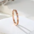 Close-up detail of an elegant rose gold ring featuring three inlaid sparkling zircons - US 5 / Rose Gold