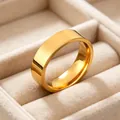 Close-up macro view of a 6mm polished gold stainless steel band ring in a velvet tray - Size 5 / Gold