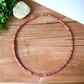 Detailed view of natural pink semi-precious stone beaded necklace on wood grain - Pink Spacers