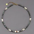 Detailed view of a beaded necklace with green semi-precious stones and white discs - Green-Black Spacers with White Shell