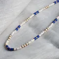 Detailed view of handmade beaded necklace with blue white and gold discs - Blue & White Patchwork Spacers