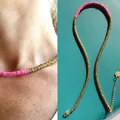 Close-up detail of pink and gold beaded necklace with heart charm on teal background - Pink & Gold Flake Spacers