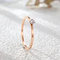 Close-up of minimalist rose gold titanium steel ring with a single round zircon stone. - US 5 / Rose Gold