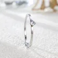 Macro view of a minimalist silver-toned titanium steel ring with a round zircon stone. - US 5 / Silver