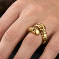 Close-up detail showing the intricate texture of a vintage gold-toned stainless steel skull ring. - US 7 / Gold