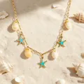Dettaglio ravvicinato di una collana a catena dorata con conchiglie e stelle marine blu - Collana Stella Marina Conchiglia (86512)