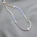 Close-up detail of bohemian rainbow seed bead necklace featuring irregular freshwater pearls - Short Choker Length / White Blue Purple