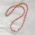 Close-up of bohemian dopamine style seed bead necklace with irregular freshwater pearl - Short Choker Length / Orange