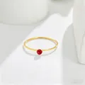 Close-up of a minimalist 14K gold ring featuring a delicate round red gemstone. - US 5 / Gold (Red Rhinestone)