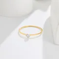 Close-up detail of a minimalist 14K gold ultra-thin ring with a small round-cut gemstone - US 5 / Gold (White Rhinestone)