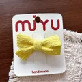 Handgefertigte milchgelbe gestrickte Haarschleife auf einer weißen Displaykarte - 6-Krokodilklemmen mit Strickschleife