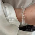 Irregular clear crystal bead bracelet worn on wrist with elegant white linen sleeve - New Arrival Crystal Bracelets
