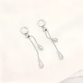 Detailansicht silberner Edelstahlohrringe mit Wassertropfenquasten auf Seide - Ohrstecker / Silber
