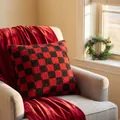 Cozy red and black checkerboard fleece throw pillow cover on a comfy grey armchair. - Red and Black Gingham