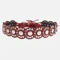 Close-up of bohemian red leather circle belt with silver rivets and embossed sun patterns - Bright Silver Wine Red