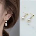 Elegante oorbellen met natuurlijke zoetwaterparels en een 18-karaats vergulde afwerking. - Eén maat / Oorbellen met twee parels van verschillende grootte