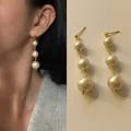Eleganti orecchini pendenti a tre perle crema graduate con finitura placcata oro 18 carati - Taglia unica / Orecchini con perle testurizzate