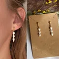 Orecchini con perle d'acqua dolce naturali su perni in acciaio al titanio dorato - Taglia unica / Orecchini con tre perle a chicco di riso