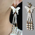 Eleganti orecchini a farfalla con perle d'acqua dolce naturali e finitura oro 18K. - Taglia unica / Orecchini a nappa con farfalla in conchiglia bianca