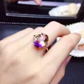 Gros plan élégant d'une bague en or rose avec une grande améthyste bicolore ovale - Bague avec pierres précieuses colorées