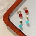 Gros plan de boucles d'oreilles rétro avec pierres naturelles et perles d'eau douce. - Rouge/Blanc/Vert/Bleu