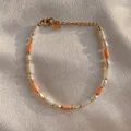 Primer plano de pulsera con perlas y piedras color melocotón sobre seda suave - Pulsera de perlas artificiales mezcla rosa y blanca / Cuerda Elástica de 16cm