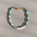 Vista detallada de una pulsera de cuentas bohemia con tubos turquesas y perlas blancas. - Pulsera espaciadora de perlas artificiales de concha